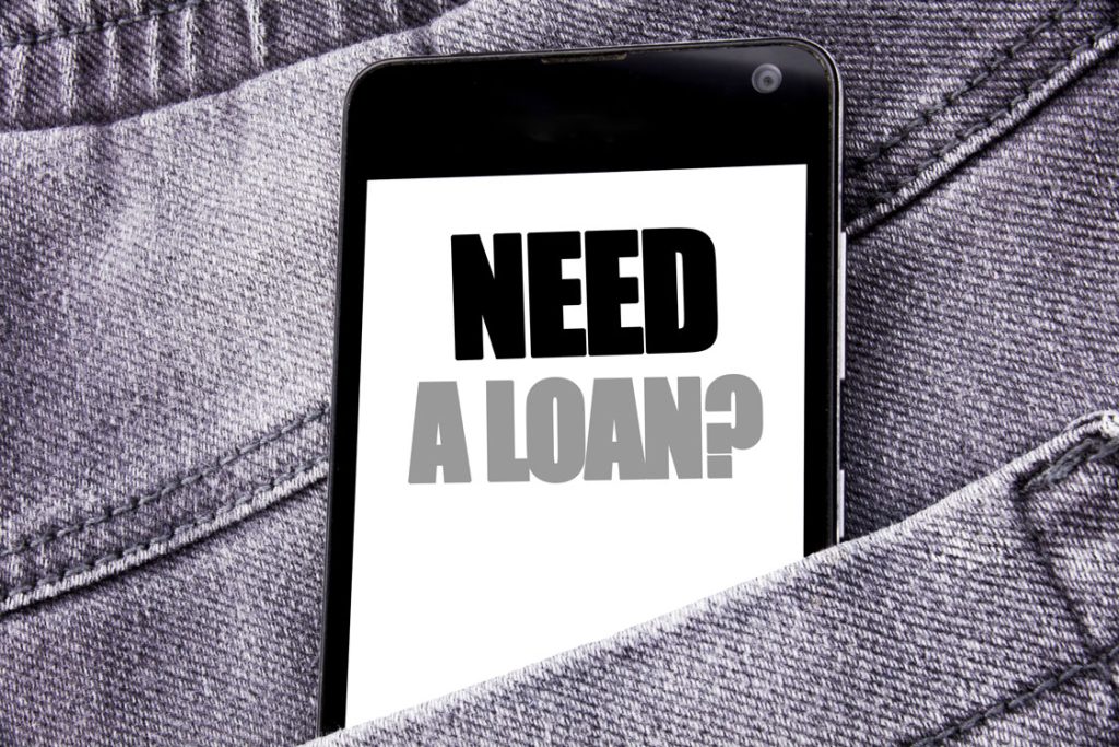 Loan shark advertisements on mobile phone screen hidden in trousers saying "need a loan?''
